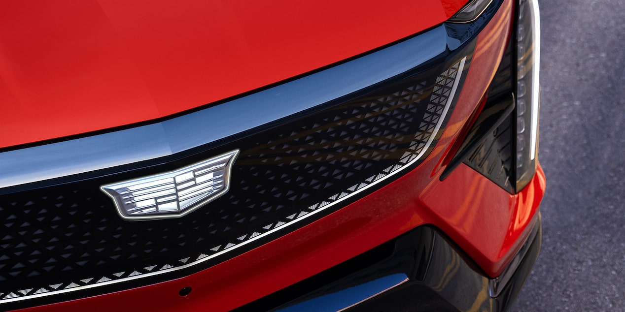 Cadillac OPTIQ 2027 con detalle del emblema en la parrilla frontal