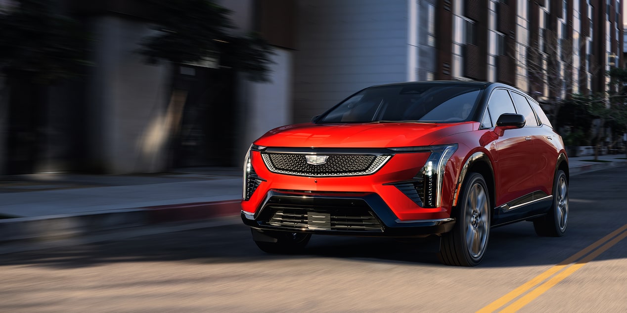 Cadillac OPTIQ 2027 en color Radiant Red circulando por la ciudad