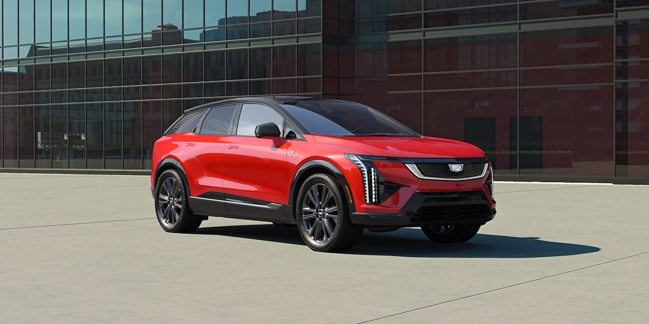 Cadillac OPTIQ 2027 frente a un edificio de arquitectura moderna