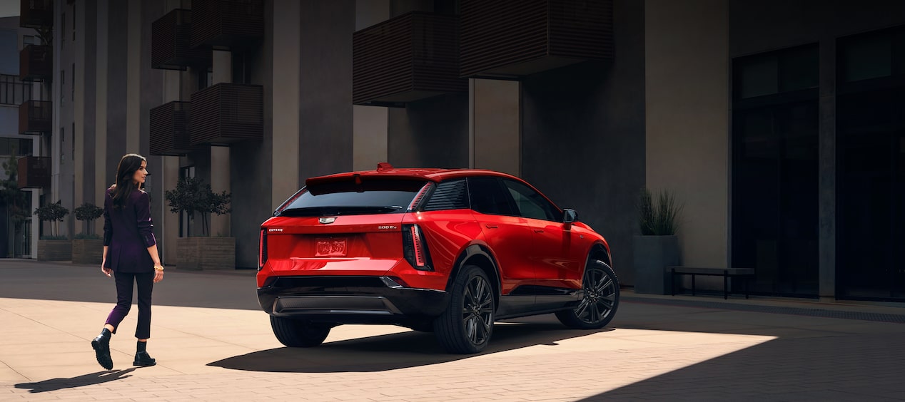 Cadillac OPTIQ 2027 en vista trasera de tres cuartos sobre una plaza. Conoce precios y promociones